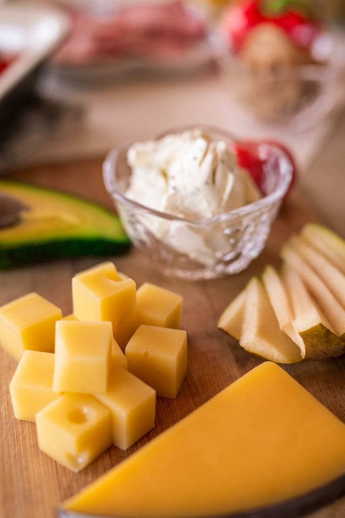A delicious cheese platter featuring assorted cheeses, fresh fruit, and creamy cheese, ideal for a gourmet snack.